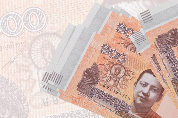 100 Kamboçyalı isyan faturası büyük yarı şeffaf banknotun arka planında duruyor. Ulusal para biriminin soyut sunumu. İş konsepti