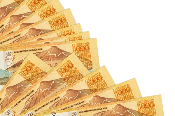 1000 adet Kazakistan tenge banknotu beyaz arka planda izole edilmiş ve fana yakın bir kopya alanı yığılmış. Maaş zamanı kavramı veya finansal işlemler