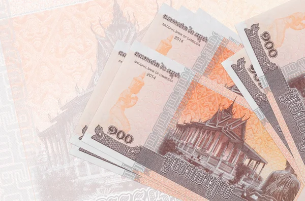 100 Kamboçyalı isyan faturası büyük yarı şeffaf banknotun arka planında duruyor. Ulusal para biriminin soyut sunumu. İş konsepti