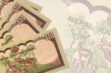 10 Nepal Rupisi banknotları büyük yarı şeffaf banknotların arka planında duruyor. Kopyalama alanı olan soyut iş arkaplanı