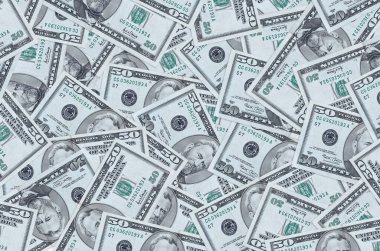 50 dolarlık banknotlar yığının içinde yatıyor. Zengin yaşam kavramsal geçmişi. Büyük miktarda para.