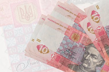 10 Ukrayna hrivniası banknotları büyük yarı şeffaf banknotların arka planında duruyor. Ulusal para biriminin soyut sunumu. İş konsepti
