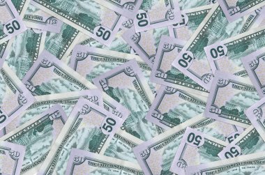 50 dolarlık banknotlar yığının içinde yatıyor. Zengin yaşam kavramsal geçmişi. Büyük miktarda para.