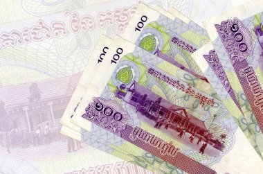 100 Kamboçyalı isyan faturası büyük yarı şeffaf banknotun arka planında duruyor. Ulusal para biriminin soyut sunumu. İş konsepti