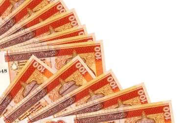 100 Sri Lanka Rupisi banknotları beyaz arka planda izole edilmiş, fotokopi alanı da pervaneye yakın duruyor. Maaş zamanı kavramı veya finansal işlemler