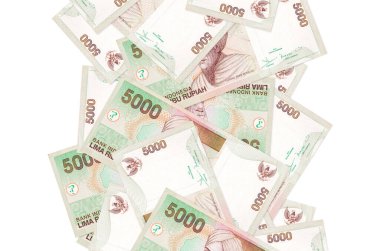 5000 Endonezya rupia banknotu beyazın üzerinde izole bir şekilde uçuyor. Birçok banknot sol ve sağ tarafta beyaz kopya alanı ile düşüyor
