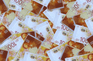 100 İsrailli yeni şekel banknot yığını içinde yatıyor. Zengin yaşam kavramsal geçmişi. Büyük miktarda para.
