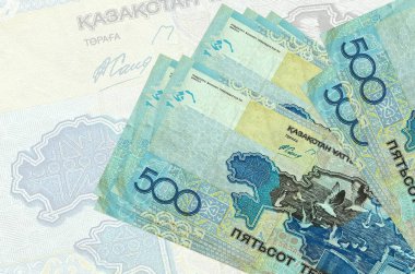 500 Kazakistan tenge faturası büyük yarı şeffaf banknotun arka planında duruyor. Ulusal para biriminin soyut sunumu. İş konsepti