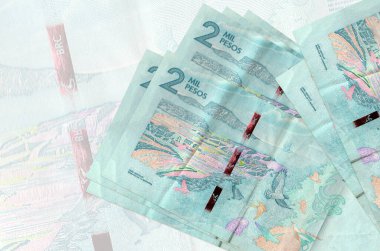 2 Kolombiya pezosu büyük yarı şeffaf banknotun arka planında duruyor. Ulusal para biriminin soyut sunumu. İş konsepti