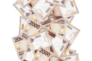 2000 Endonezya rupiası banknotları beyazın üzerinde izole bir şekilde uçuyor. Birçok banknot sol ve sağ tarafta beyaz kopya alanı ile düşüyor