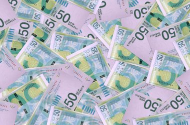 50 İsrailli yeni şekel banknot yığını içinde yatıyor. Zengin yaşam kavramsal geçmişi. Büyük miktarda para.