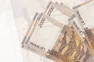 2000 Endonezya rupiası banknotları büyük yarı şeffaf banknotların arka planında duruyor. Ulusal para biriminin soyut sunumu. İş konsepti