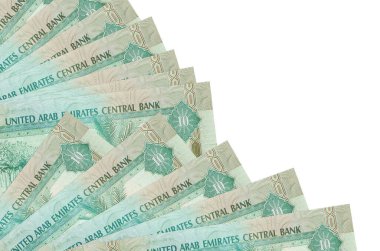 10 BAE dirhem banknotu beyaz arka planda izole edilmiş ve fanı da kapatılıyor. Maaş zamanı kavramı veya finansal işlemler