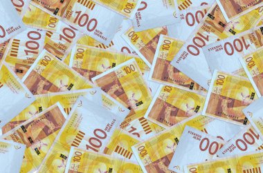 100 İsrailli yeni şekel banknot yığını içinde yatıyor. Zengin yaşam kavramsal geçmişi. Büyük miktarda para.