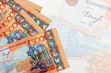 5000 Kazakistan tenge faturası büyük yarı şeffaf banknotun arka planında duruyor. Kopyalama alanı olan soyut iş arkaplanı