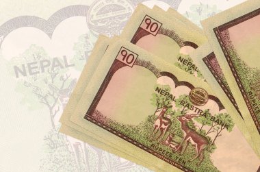 10 Nepal Rupisi banknotları büyük yarı şeffaf banknotların arka planında duruyor. Ulusal para biriminin soyut sunumu. İş konsepti