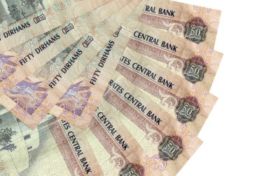 50 BAE dirhem banknotları beyaz arka planda izole edilmiş, fotokopi alanı da yakın planda. Finansal işlemler kavramı