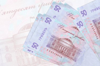 50 Ukrayna hrivniası banknotları büyük yarı şeffaf banknotların arka planında duruyor. Ulusal para biriminin soyut sunumu. İş konsepti