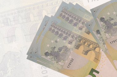 Büyük yarı şeffaf banknotun arka planında 5 avroluk banknotlar duruyor. Ulusal para biriminin soyut sunumu. İş konsepti