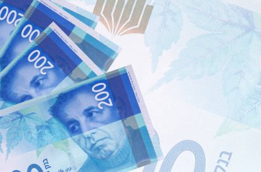 200 İsrailli yeni şekel banknotları büyük yarı şeffaf banknotların arka planında duruyor. Kopyalama alanı olan soyut iş arkaplanı