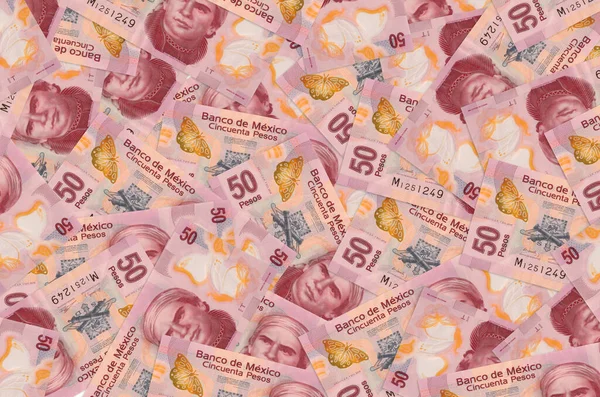 50 Meksika pezosu yığının içinde yatıyor. Zengin yaşam kavramsal geçmişi. Büyük miktarda para.