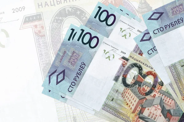 100 Belorus rublesi banknotları büyük yarı şeffaf banknotların arka planında duruyor. Ulusal para biriminin soyut sunumu. İş konsepti