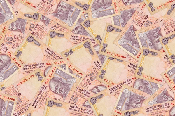 10 tane Hint rupisi büyük bir yığın halinde duruyor. Zengin yaşam kavramsal geçmişi. Büyük miktarda para.