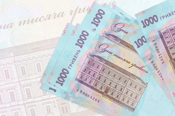 1000 Ukrayna hrivniası banknotları büyük yarı şeffaf banknotların arka planında duruyor. Ulusal para biriminin soyut sunumu. İş konsepti