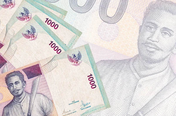 1000 Endonezya rupiası banknotları büyük yarı şeffaf banknotların arka planında duruyor. Kopyalama alanı olan soyut iş arkaplanı