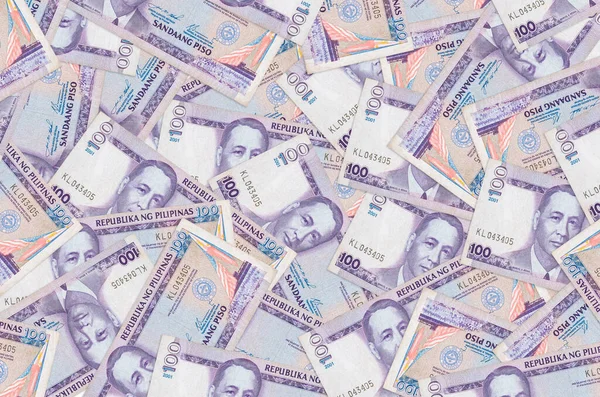 100 Filipin piso faturası büyük bir yığın halinde duruyor. Zengin yaşam kavramsal geçmişi. Büyük miktarda para.