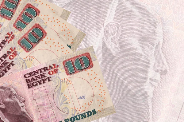 10 Mısır sterlinli banknotlar büyük yarı şeffaf banknotların arka planında duruyor. Kopyalama alanı olan soyut iş arkaplanı