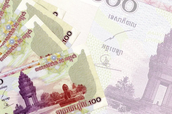 100 Kamboçyalı isyan faturası büyük yarı şeffaf banknotun arka planında duruyor. Kopyalama alanı olan soyut iş arkaplanı
