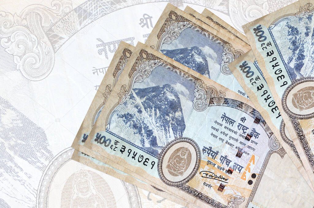 500 Nepalese rupees bills lies in stack on background of big semi-transparent banknote. Abstract presentation of national currency. Business concept