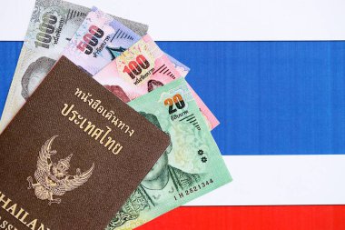 Tayland baht para ve pasaport banknotları bayraklarda asılı. Seyahat ve tatil kavramı