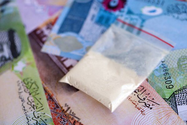 Bahraini dinar currency money bills and cocaine pack close up. The concept of drug trafficking