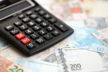 Brezilya banknotları ve hesap makinesi. Mevcut Brezilya gerçek para ve hesap makinesi büyük miktarda masada yatıyor. Brezilya 'da vergilendirme ve para konsepti