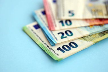Avrupa para birimi banknotlarının büyük bir miktarı mavi renkli masaya yakın. Avrupa 'da iş ve gelir kavramı