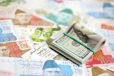 Bir sürü Amerikan doları Pakistan Rupileri 'nin banknotlarına yakın duruyor. Amerikan para demeti Pakistan 'ın para banknotlarında yatıyor. Pakistan 'da ekonomi ve döviz kuru kavramı