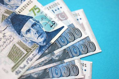 Pakistan banknotları mavi arka planda. Pakistan 'ın mevcut para faturaları büyük miktarda masada yatıyor. Pakistan 'da iş ve yatırım kavramı