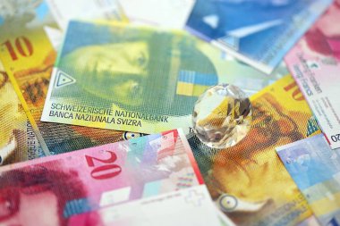İsviçre frangı banknotları ve elmaslar. Mevcut frank para ve mücevher büyük miktarda masada yatıyor. İsviçre 'de mücevher ve elmas ticareti kavramı