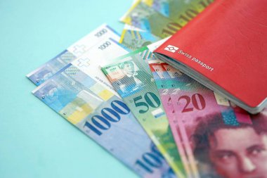 İsviçre frangı banknotları ve mavi üzerine pasaport. Mevcut para banknotları mavi üzerine kuruludur. İsviçre 'de iş ve yatırım kavramı