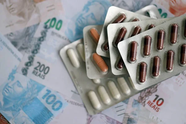 Brezilya bankaları ve ilaç hapları. Mevcut Brezilya gerçek para ve uyuşturucu banknotları büyük miktarda masada yatıyor. Brezilya 'da ilaç ve eczane kavramı