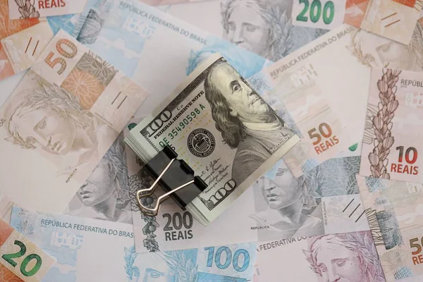 Bir sürü Amerikan doları büyük miktarda Brezilya banknotunun üzerinde yatar. Amerika 'nın parası Brezilya' nın para akışına bağlı. Brezilya 'da ekonomi ve döviz kuru kavramı