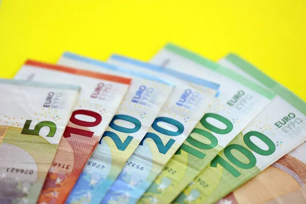 Avrupa para birimi banknotlarının büyük bir miktarı sarı renkli masaya yakın. Avrupa 'da iş ve gelir kavramı
