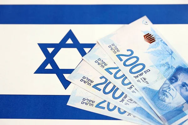 Israel New Shekels banknotları ulusal bayrak üzerinde. İsrail 'in şu anki para faturaları büyük oranda bayrağın üzerinde yatıyor. İsrail 'de iş ve yatırım kavramı