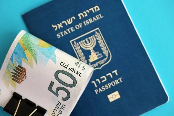 Israel New Shekels banknotları ve mavi arka planda pasaport. İsrail 'in şu anki para banknotları büyük oranda mavi üzerine yatar. İsrail 'de finans ve nakit kavramı
