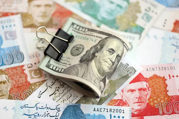 Amerikan dolarlarının rulosu Pakistan 'daki büyük miktardaki banknotların üzerinde yatıyor. Amerikan para demeti Pakistan 'ın para banknotlarında yatıyor. Pakistan 'da ekonomi ve döviz kuru kavramı