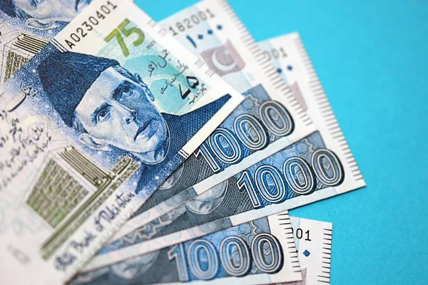 Pakistan banknotları mavi arka planda. Pakistan 'ın mevcut para faturaları büyük miktarda masada yatıyor. Pakistan 'da iş ve yatırım kavramı