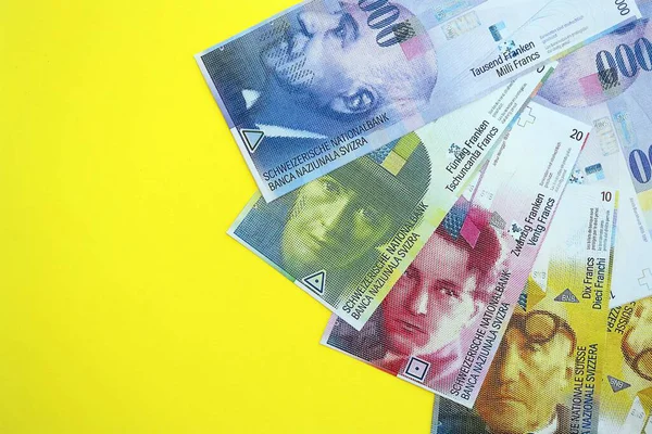 Sarıya İsviçre frangı banknotları. Mevcut frank para faturaları büyük miktarda masada yatıyor. İsviçre 'de iş ve yatırım kavramı