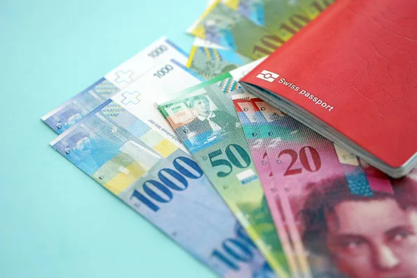 İsviçre frangı banknotları ve mavi üzerine pasaport. Mevcut para banknotları mavi üzerine kuruludur. İsviçre 'de iş ve yatırım kavramı